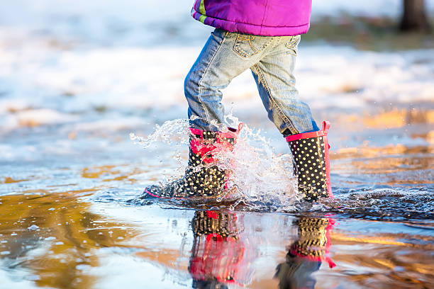 istock Waist Down of Child Walking Through Springtime Puddle 511211160