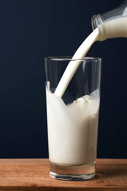 Pouring milk in a glass stock photo