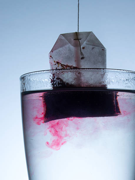 istock tea bag is brewed in water with beautiful abstract stains 511213852