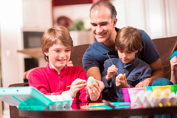 istock Family decorating Easter eggs at home.  Father, sons. 511218566