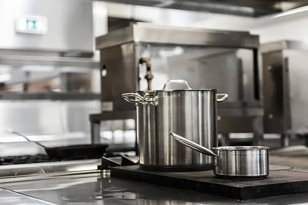 Pots standing on hotplate in professional kitchen