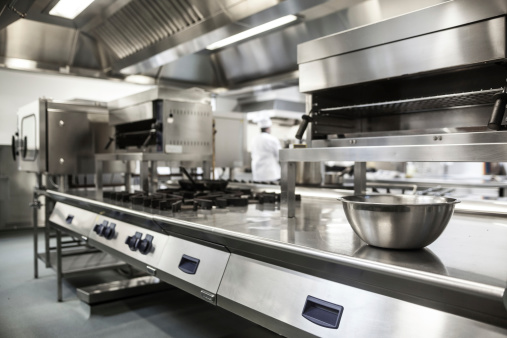 A chef is cooking in his restaurant's kitchen. Shot through the glass. High-end gourmet restaurant.