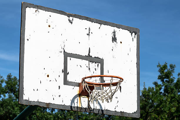istock Old basketball hoop under a blue sky 511244509