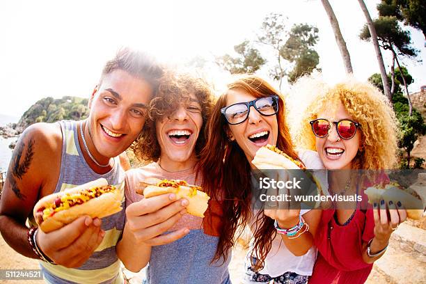 Friends Eating Hotdogs Stock Photo - Download Image Now - Hot Dog, Eating, Friendship