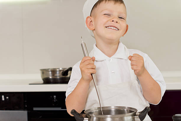 istock Happy young boy enjoying cooking 511244753
