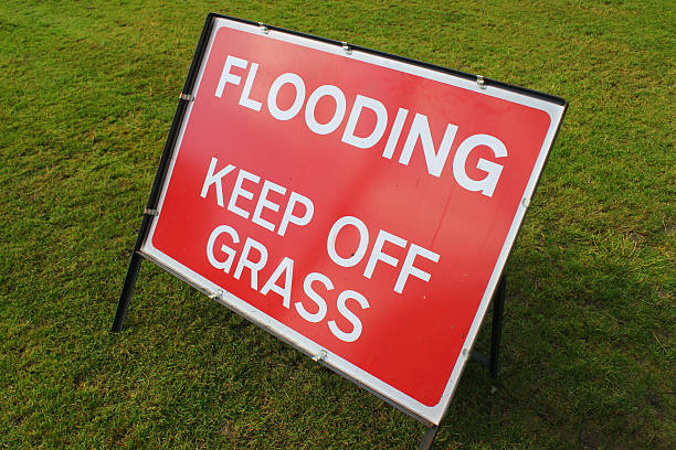 istock Image of sign saying 'Flooding, Keep Off Grass' in park 511245575