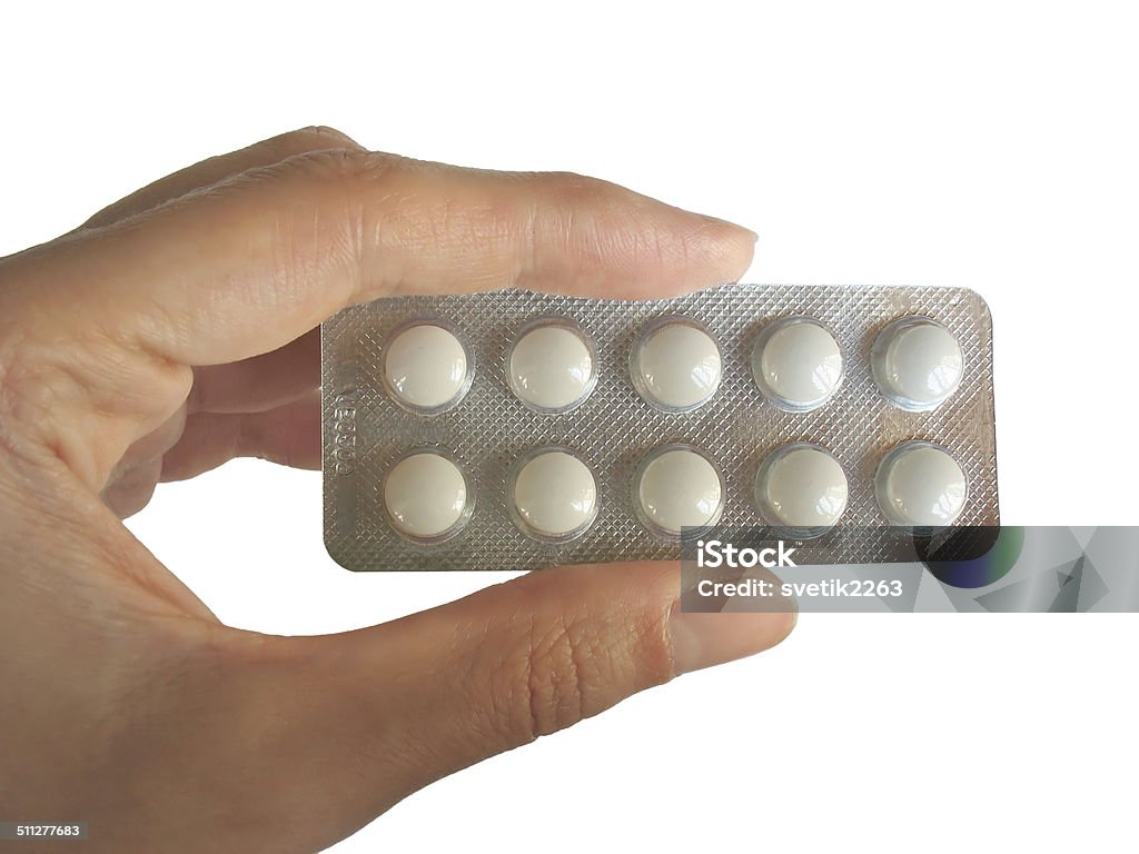 Blister of piles in the hand isolated on white Blister of tablets in woman's fingers isolated on white Adult Stock Photo