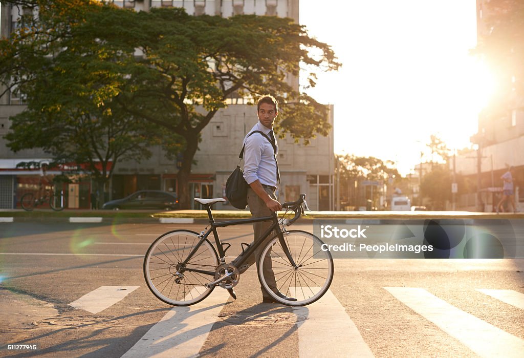 The no stress work commute Shot of an attractive young man pushing his bicycle on the way to work Commuter Stock Photo