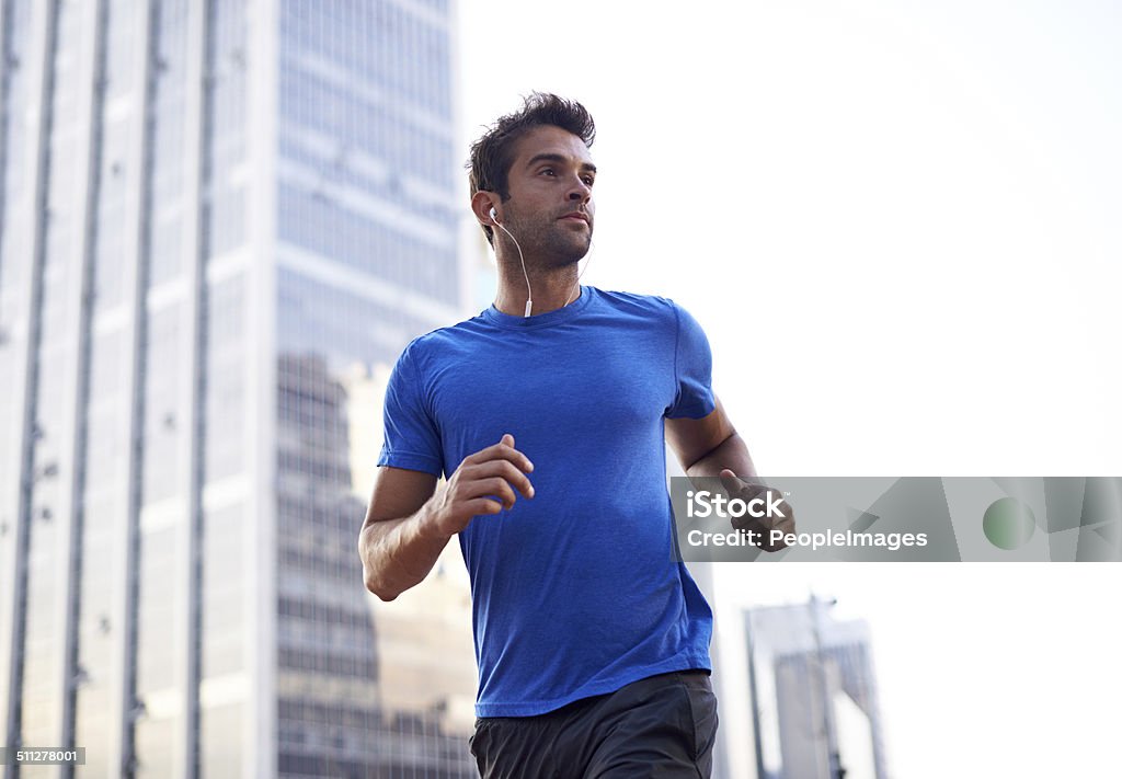 I run to the pulse of my city Shot of an attractive young man out for a run through the city Running Stock Photo