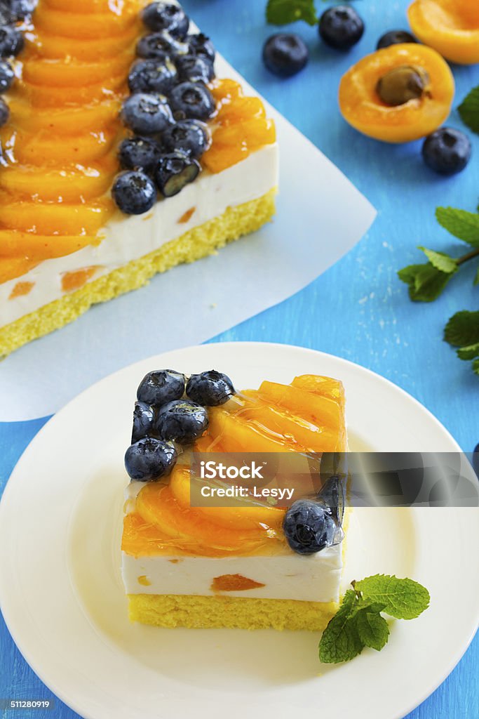 Sponge cake with yogurt mousse, apricots and blueberries. Apricot Stock Photo