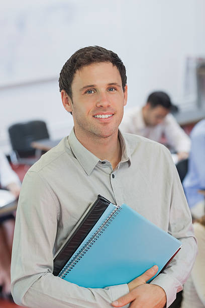 istock Handsome male teacher posing in his classroom 511281713