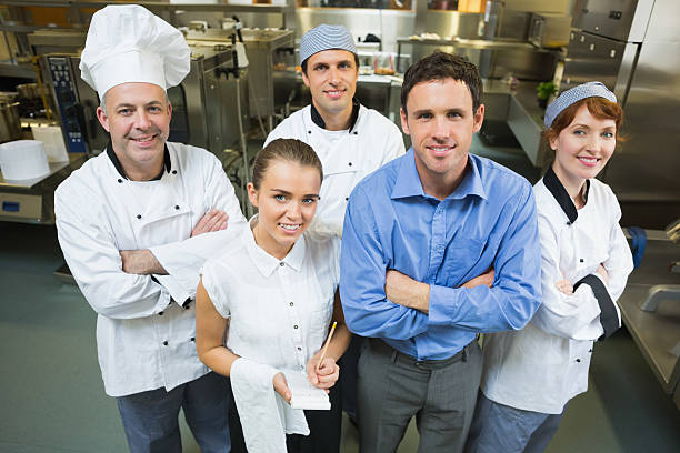 istock Handsome manager posing with some chefs and waitress 511284015