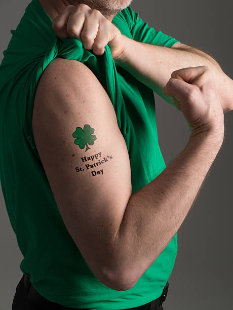 Man in Green T Shirt Brandishes St. Patrick's Day Tattoo stock photo