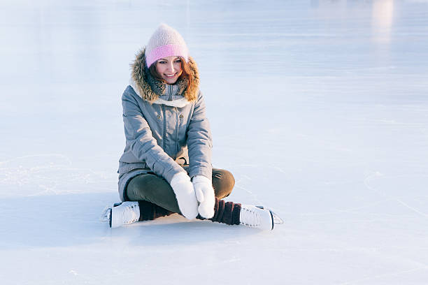 istock Ice skating woman sitting on the ice smiling 511301856