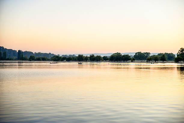 people are rowing at sunrise on lake Burley Griffin
