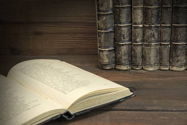 istock Single Open Book And Old Shabby Books In Row 511305768