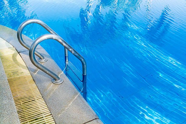 istock swimming pool bar ladder in light blue water 511308286