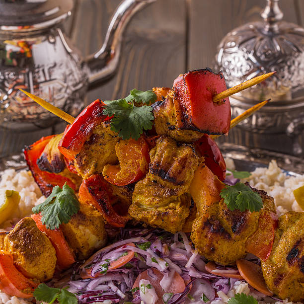 istock Grilled chicken and vegetable kebabs served with rice and salad. 511308440
