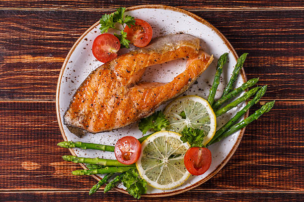 istock Grilled salmon steak served with asparagus, tomato and lemon. 511308820