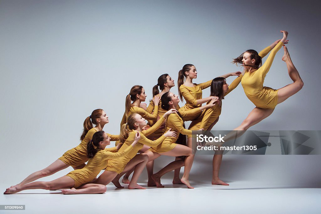 The group of modern ballet dancers The group of modern ballet dancers dancing on gray background Dancing Stock Photo