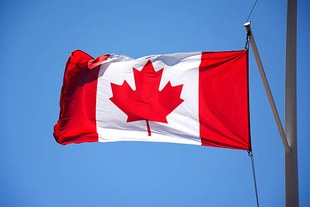 istock Canadian Flag in blue sky 511313494
