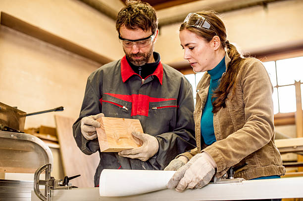istock Carpenters Examining Piece of Wood in Workshop 511313576