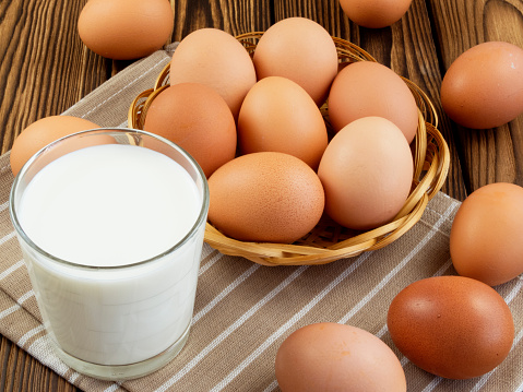 Eggs and a glass of milk on wooden table