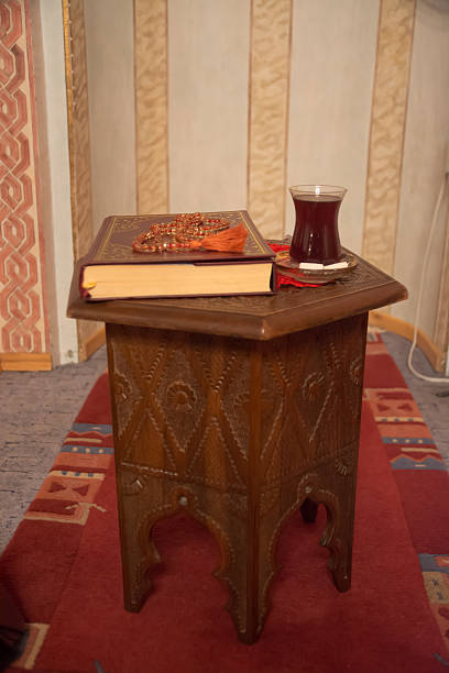 Muslim Koran on table with prayer beads and turkish tea