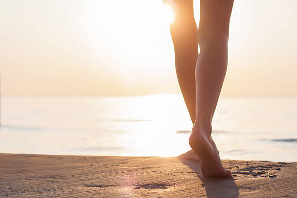 istock Woman walking on the beach at sunset 511324533