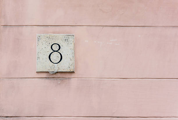 istock Pink colored wall with number eight plaque 511324561