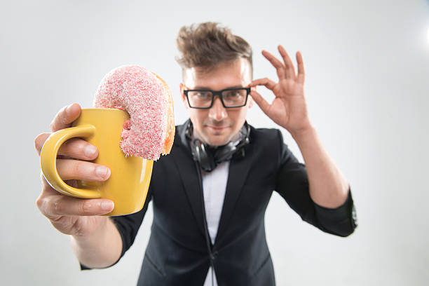 istock Dj handsome hipster eating donut from his cup on working 511325073