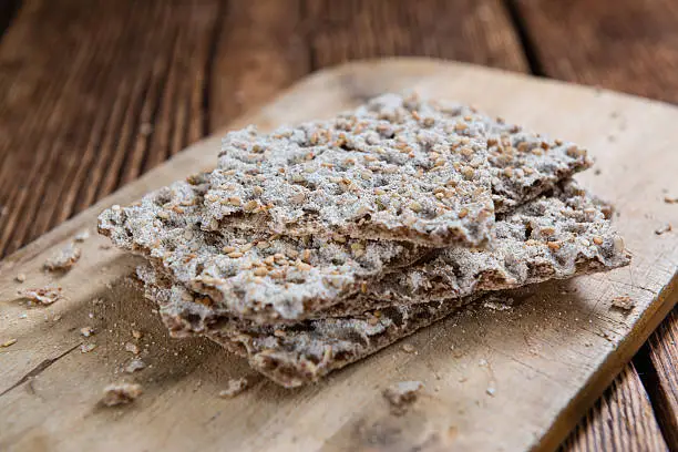 Crispbread (selective focus) on an old wooden table (close-up shot)