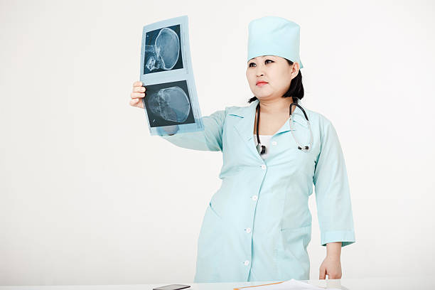 jovem asiático médico com estetoscópio olhando no x - healthcare and medicine the human body x ray image human bone - fotografias e filmes do acervo
