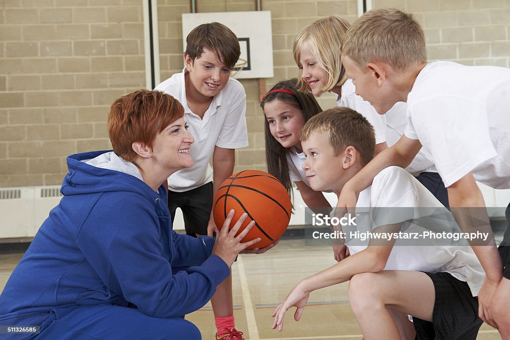 Entrenador personal que hable del equipo de básquetbol de la escuela primaria - Foto de stock de Baloncesto libre de derechos