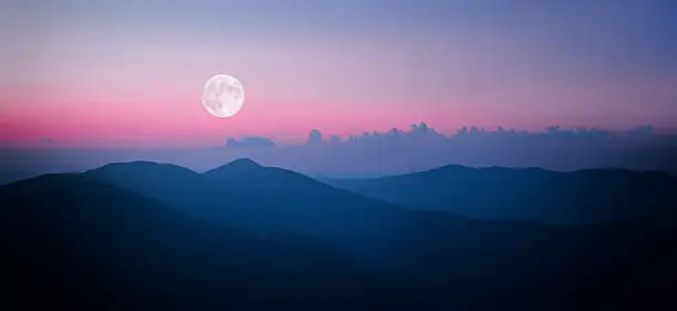 Fool moon rising over the mountain range in Carpathians