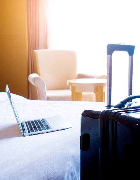 istock Laptop and suitcase in hotel room 511328090