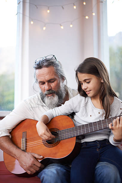 ajudando as suas habilidades com seu violão - listening child grandfather family - fotografias e filmes do acervo