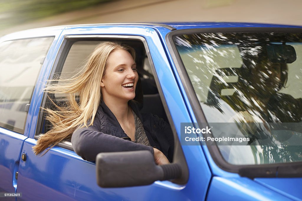 Feeling the wind in her hair A young woman feeling the wind in her hair through an open car window 20-24 Years Stock Photo