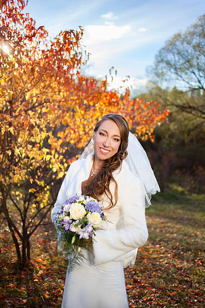 istock Young beautiful happy slim smiling bride on autumn forest background 511352799