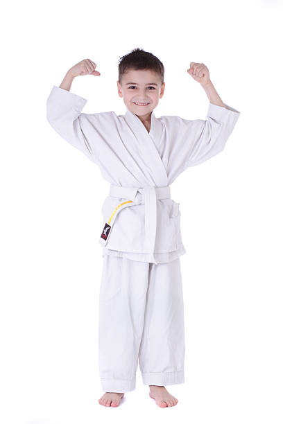 Young boy fighter in kimono with hand up stock photo
