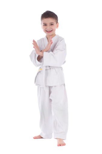 Young boy fighter in kimono taking pose isolated on white background