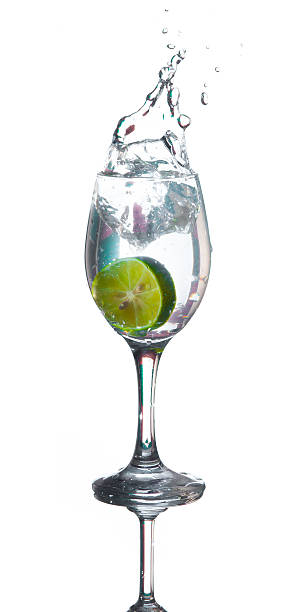 istock Lime splashing into glass of water on white background 511354905