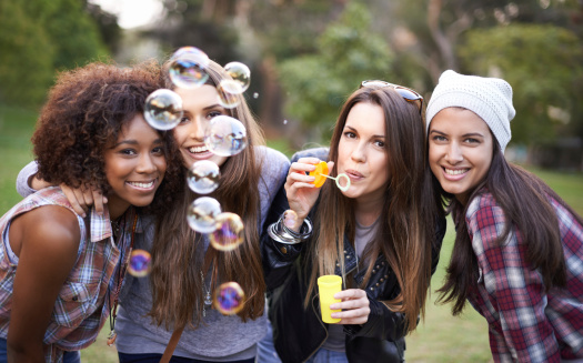Cropped shot of a group of friends enjoying a day at the park with bubbles