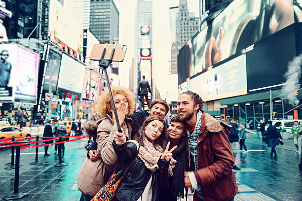 Group of friends making selfie Group of friends making selfie in Time Square times square stock pictures, royalty-free photos & images