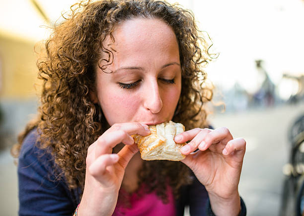 istock woman biting a snack at the cafe 511363818