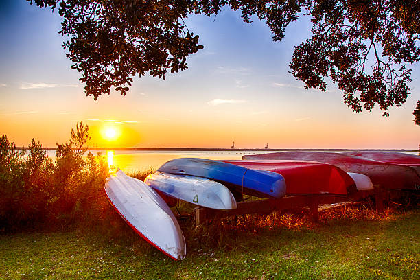 Canoes on the Bank Colorful canoes on the bank of the Cape Fear River. Kure Beach, North Carolina. cape fear stock pictures, royalty-free photos & images