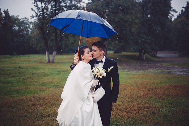istock Romantic walking of newlyweds in the rain 511367748