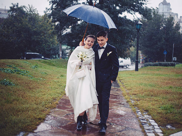 istock Romantic walking of newlyweds in the rain 511367774