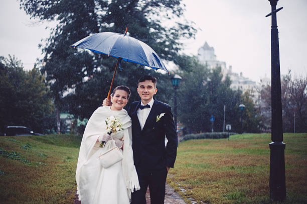 istock Romantic walking of newlyweds in the rain 511367812