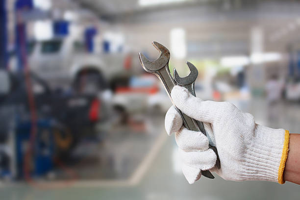 istock Technician holding wrench with car repair service centre 511369168